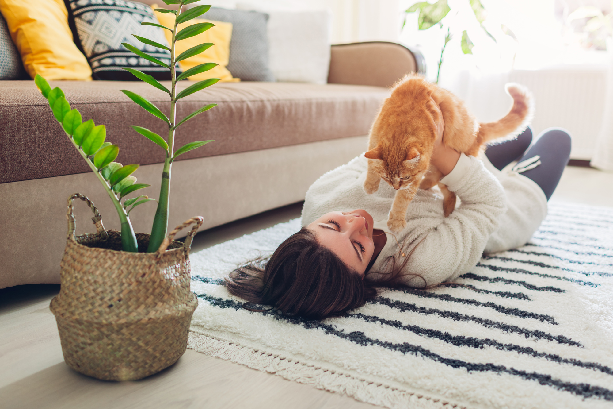 woman laying in her apartment floor with a cat